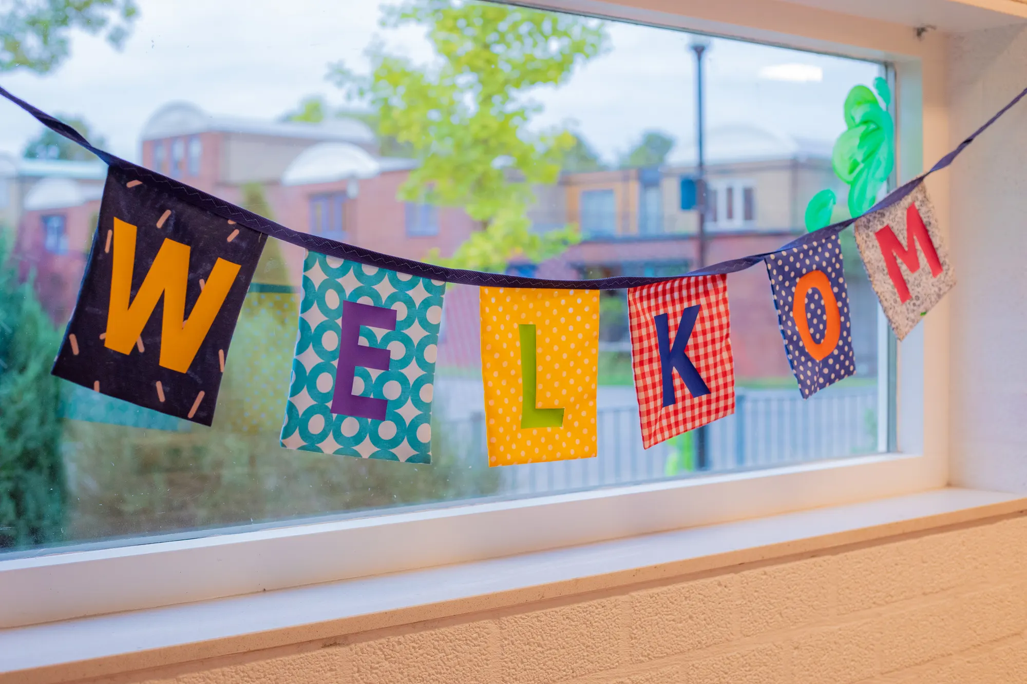 Slinger met welkom voor het schoolraam